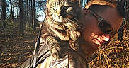 Koji is registered to the contest to win money with this photo: animal, autumn, backpack, camouflage, cat, daylight, forest, fur, hiking, leaves, man, nature, outdoors, pet, shoulder, sunglasses, sunlight, trees, walking, wildlife