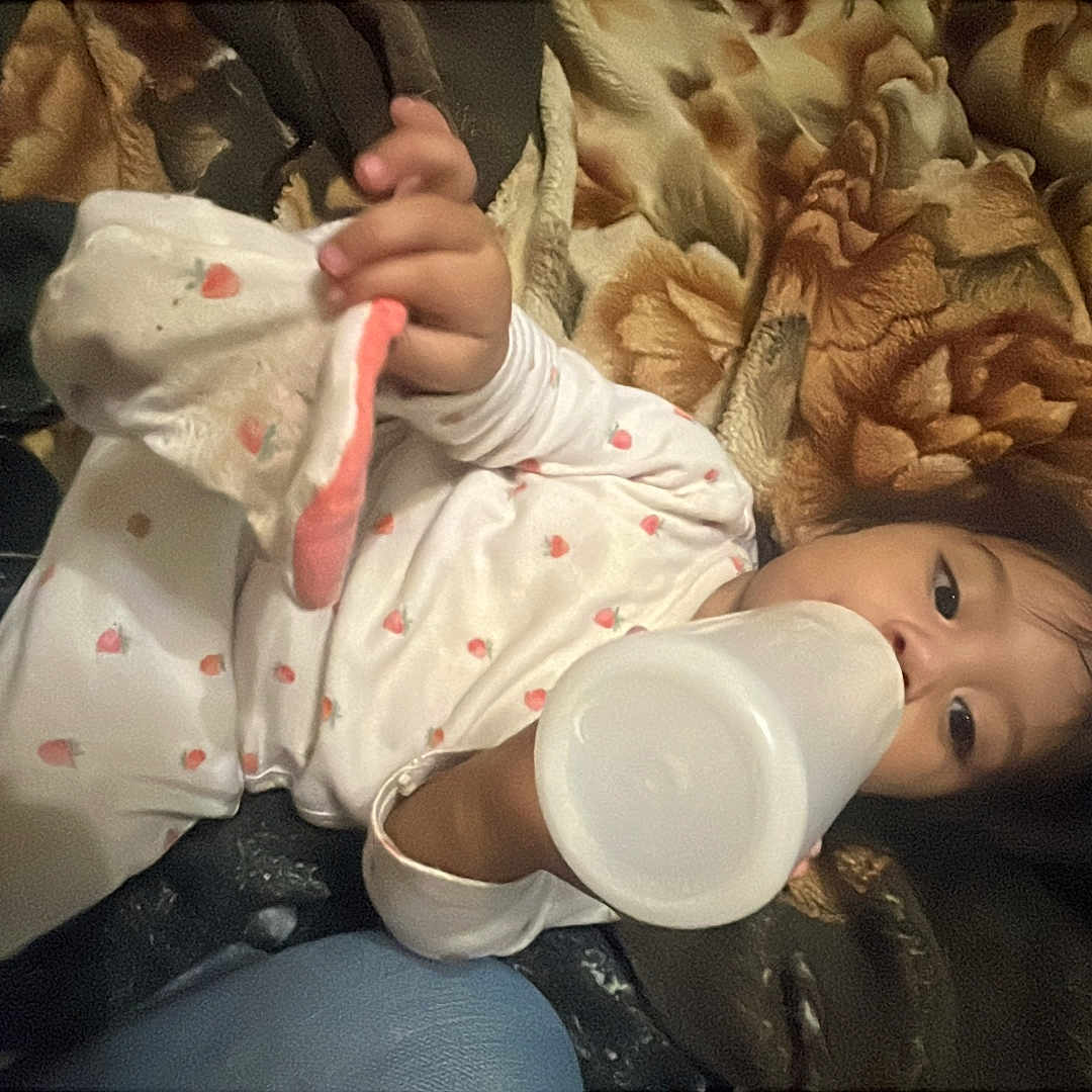 April Leija joined the competition — help win amazing prizes! baby, bedtime, blanket, bottle, child, cozy, eyes, face, feeding, floral_blanket, hair, hand, indoor, lying_down, nursery_textile, pajamas, portrait, soft_toy_cloth, strawberry_print, toddler