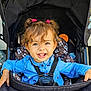 Azalia a rejoint le concours — aidez-le/la à gagner de superbes lots ! toddler, child, smiling, curly_hair, blue_shirt, stroller, baby, safety_harness, happy, cute, portrait, outdoor, person, seat, infant, clothing, playful, hair_tie, seat_cover, bright