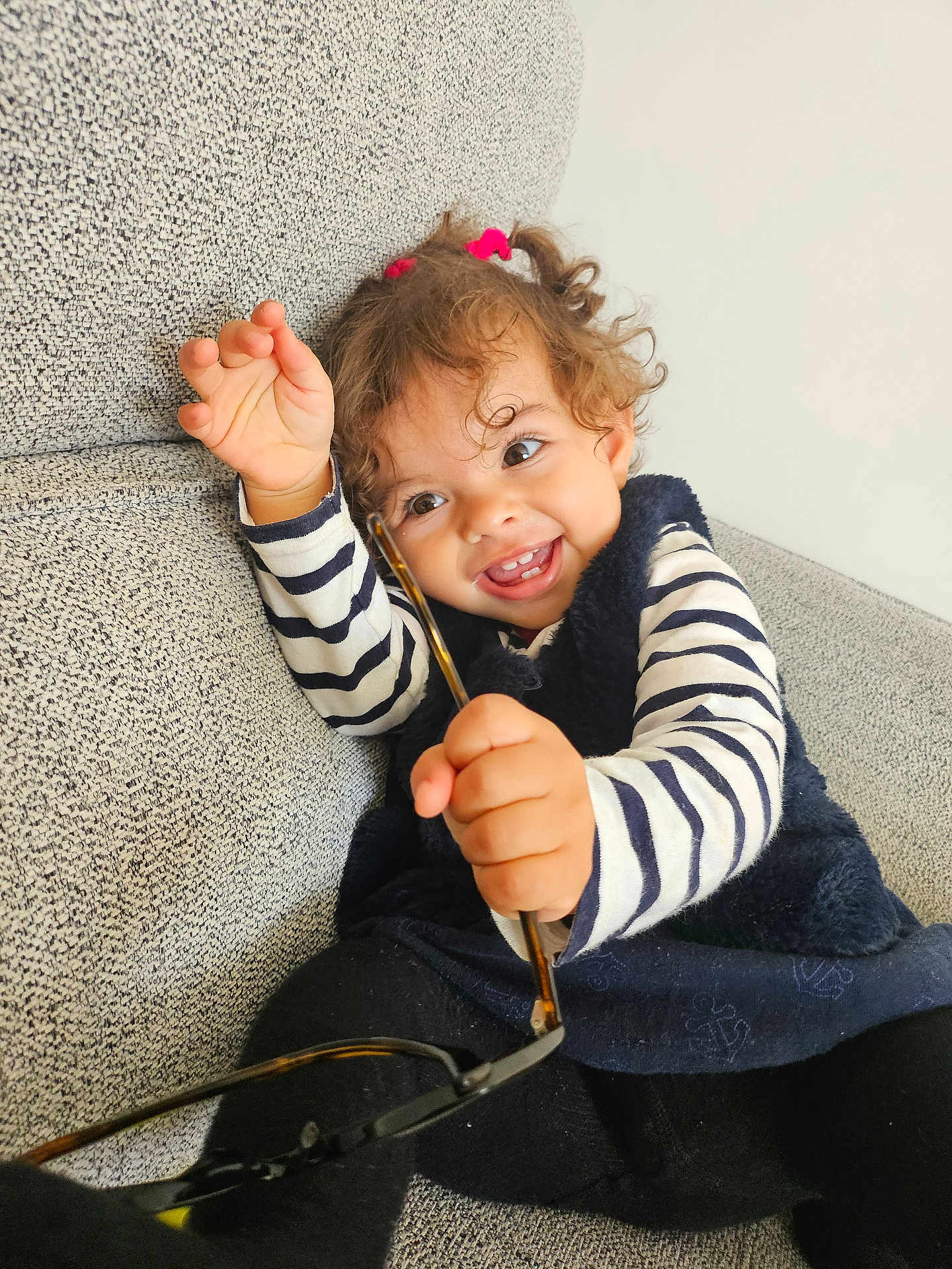 Azalia a rejoint le concours — aidez-le/la à gagner de superbes lots ! toddler, child, smile, curly_hair, glasses, striped_shirt, black_tights, blue_dress, couch, indoor, happy, playful, person, face, hand, sitting, cute, young_child, home, fun