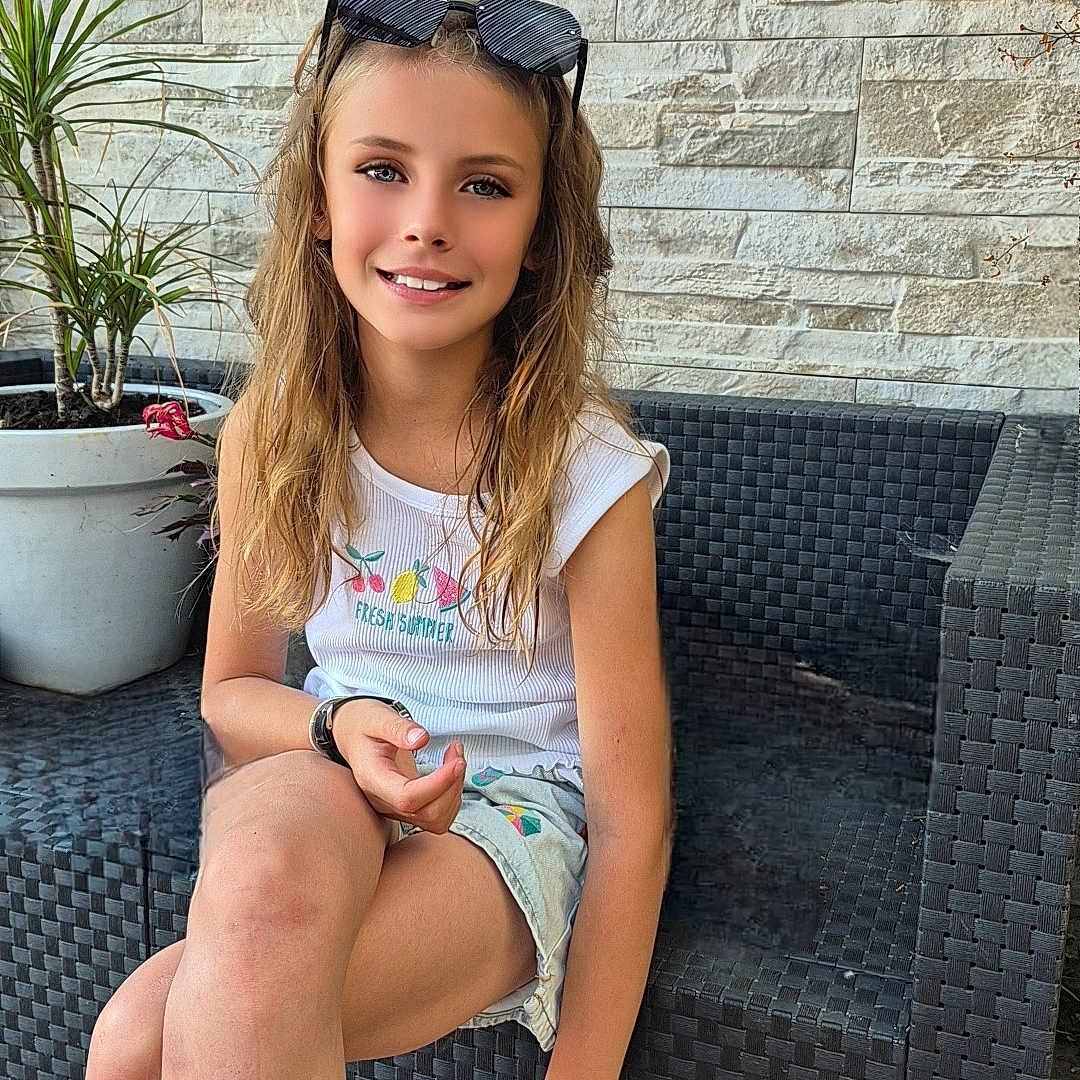 Kahina participe au concours pour gagner de l'argent avec cette photo : casual, child, girl, happy, long_hair, outdoor_furniture, plant, portrait, potted_plant, relaxed, shorts, sitting, smiling, stone_wall, sunglasses, sunny, tile_floor, white_tank_top, wicker_couch, young