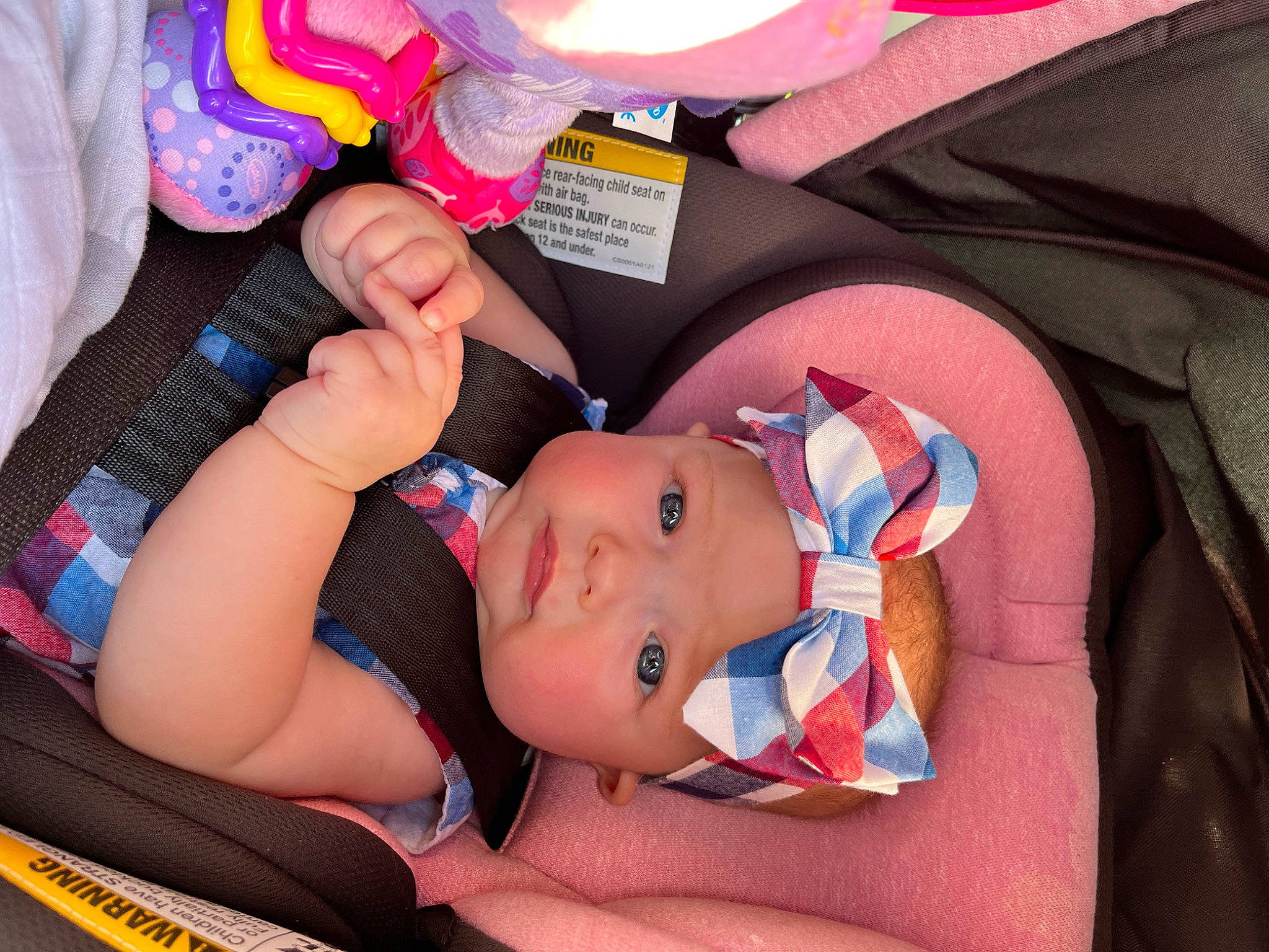 Brooklyn is registered to the contest to win money with this photo: baby, baby_carriage, baby_products, baby_toddler_clothing, car_seat, cheek, child, comfort, finger, fun, gesture, headwear, human_body, lap, mouth, nail, person, pink, red, skin