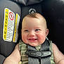 baby, child, car_seat, smiling, happy, infant, seatbelt, safety, striped_clothing, closeup, cute, rosy_cheeks, reaching_hand, indoor, portrait, head_and_shoulders, infant_toddler, baby_face, child_seat, warning_label