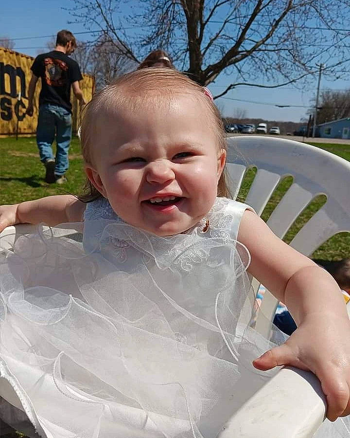 Posie is registered to the contest to win money with this photo: baby, bathing, chest, child, event, facial_expression, fun, grass, hairstyle, happy, head, leisure, person, plant, recreation, sitting, skin, sky, toddler, tree