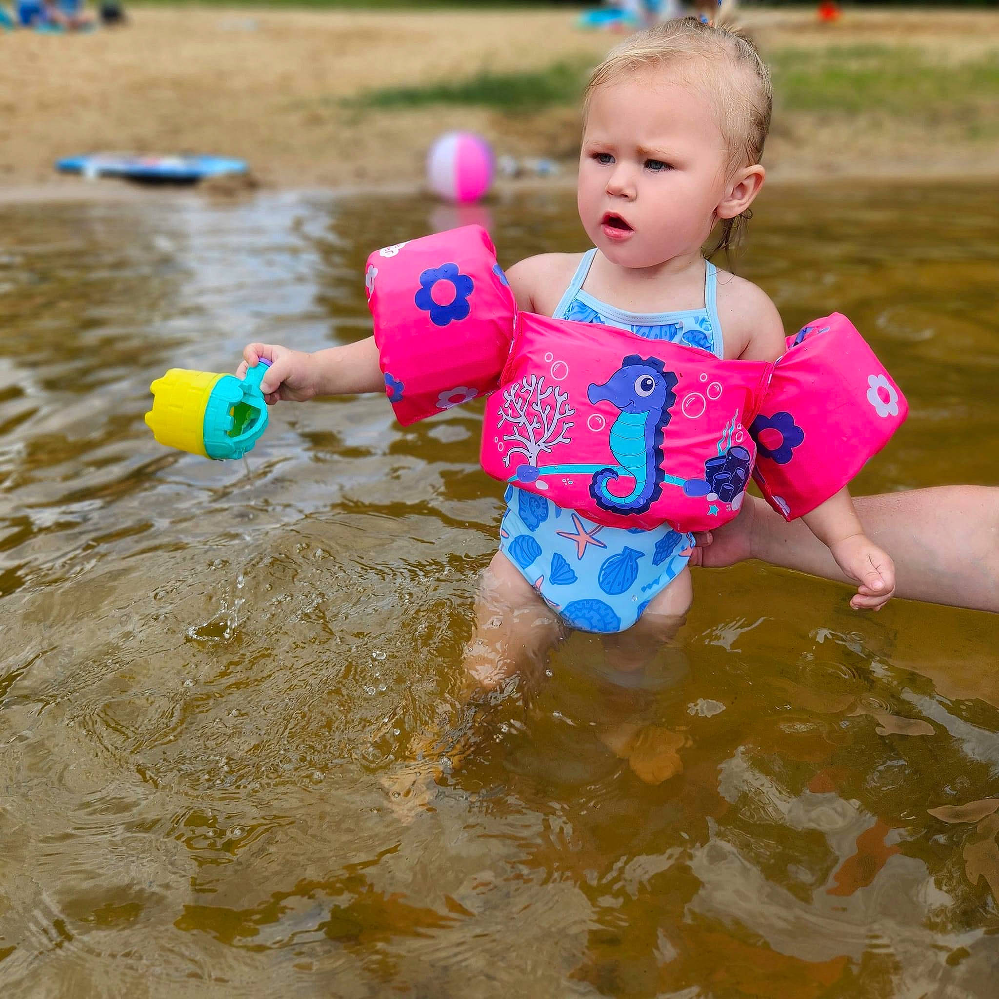 Posie is registered to the contest to win money with this photo: baby, baby_toddler_clothing, beach, child, fun, happy, leisure, ocean, people_in_nature, people_on_beach, person, personal_protective_equipment, play, recreation, sand, swimwear, t_shirt, toddler, vacation, water
