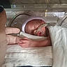 Kaven is registered to the contest to win money with this photo: baby, blanket, cap, care, finger, hand, healthcare, hope, hospital, incubator, infant, intensive_care, medical_equipment, medical_tubes, newborn, nursery, person, premature, sleeping, soft_lighting