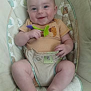 Royce is registered to the contest to win money with this photo: baby, smiling, infant, baby_seat, toy, cushion, elephant_pattern, clothing, striped_shirt, happy, cute, child, skin, legs, feet, hand, playful, indoors, comfort, portrait