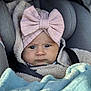 Emy a rejoint le concours — aidez-le/la à gagner de superbes lots ! baby, baby_accessory, blanket, car_seat, child, closeup, cozy, cute, face, fuzzy_jacket, headband, indoors, infant, person, pink_bow, portrait, seatbelt, serious_expression, warm_clothing, young_child