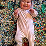 Emy a rejoint le concours — aidez-le/la à gagner de superbes lots ! baby, celebration, cheerful, child, close_up, colorful, confetti, feet, floor, hand, infant, lying_down, multicolored_balls, onesie, party, playful, portrait, ribbons, rosy_cheeks, smiling