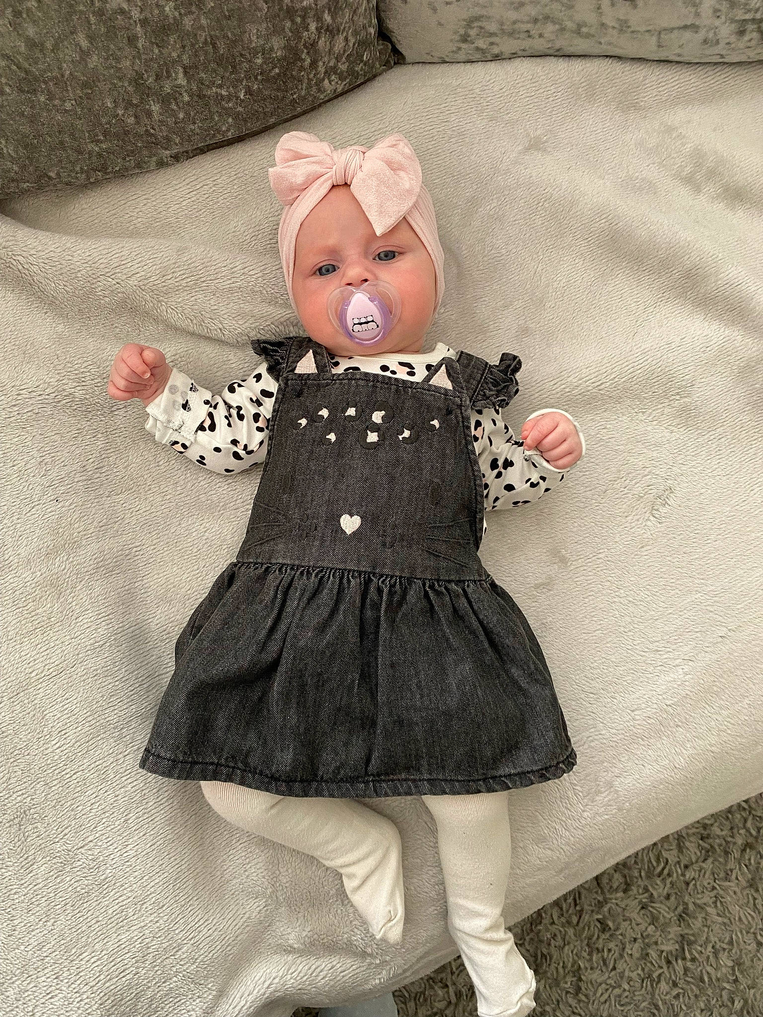 Isla-mae is registered to the contest to win money with this photo: arm, baby_toddler_clothing, day_dress, doll, dress, fashion_design, fawn, grey, hand, hat, headwear, human_body, leg, one_piece_garment, outerwear, pattern, person, pink, sleeve, textile