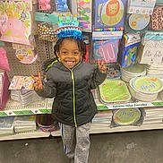 Isaiah joined the competition — help win amazing prizes! child, birthday_hat, smiling, peace_sign, party_supplies, store_aisle, jackets, sweatpants, crocs, happy, indoor, colorful, celebration, toys, decorations, face, person, retail, shopping, floor