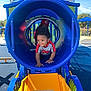 adult, blue, cap, child, crawling, curious, daytime, fun, hat, outdoor, park, person, play_equipment, playground, puma, shirt, sunny, toddler, tunnel, yellow