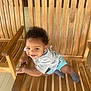 baby, blue_shorts, child, clothing, curly_hair, cute, earrings, furniture, grey_shirt, happy, outdoor, person, playful, porch, seat, smiling, socks, toddler, wood, wooden_bench