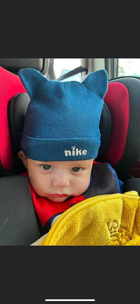 Helio participe au concours pour gagner de l'argent avec cette photo : auto_part, baby, beanie, cap, car_seat, child, costume_hat, electric_blue, fashion_accessory, font, fun, happy, hat, head_restraint, headgear, headwear, knit_cap, person, product, snapshot