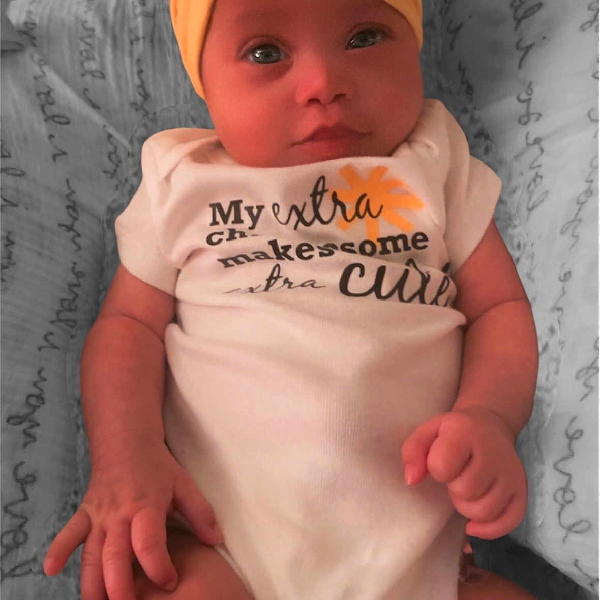 Shine is registered to the contest to win money with this photo: adorable, baby, blanket, child, clothing, cute, expression, face, hands, headband, indoor, infant, lying, newborn, onesie, pattern, person, portrait, soft_light, yellow