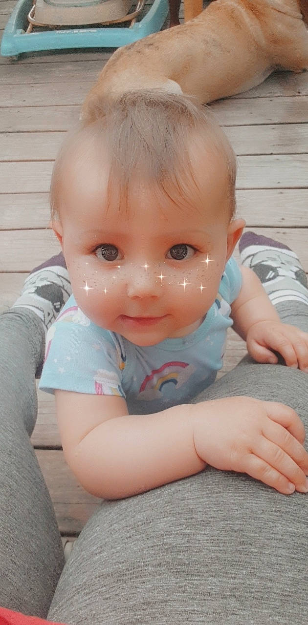 Fraya is registered to the contest to win money with this photo: baby, cheek, child, ear, eye, face, finger, forehead, hand, head, iris, lip, nose, person, sitting, skin, smile, toddler, tummy_time