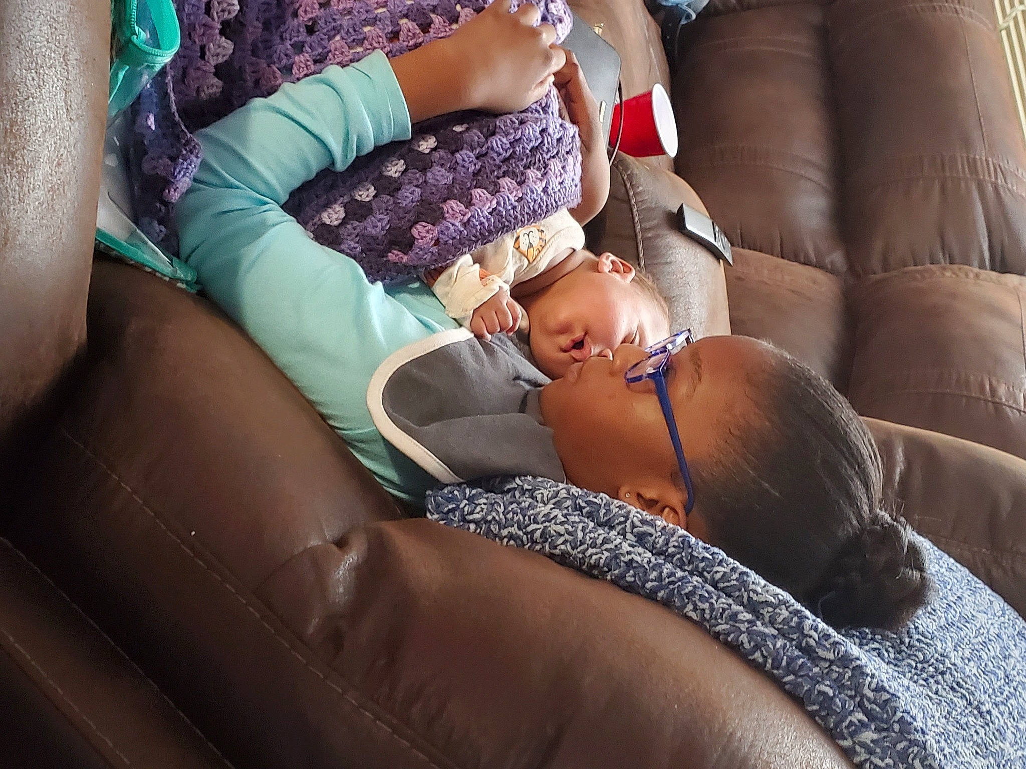 London is registered to the contest to win money with this photo: baby, blond, car_seat, comfort, couch, eyewear, fun, glasses, hat, human_leg, knee, lap, leg, leisure, nail, person, sitting, textile, thigh, toddler