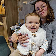 Oscar a rejoint le concours — aidez-le/la à gagner de superbes lots ! toddler, child, woman, glasses, smile, indoor, kitchen, vest, corduroy_pants, holding, family, happy, person, portrait, clothing, casual, home, warm_lighting, furniture, background