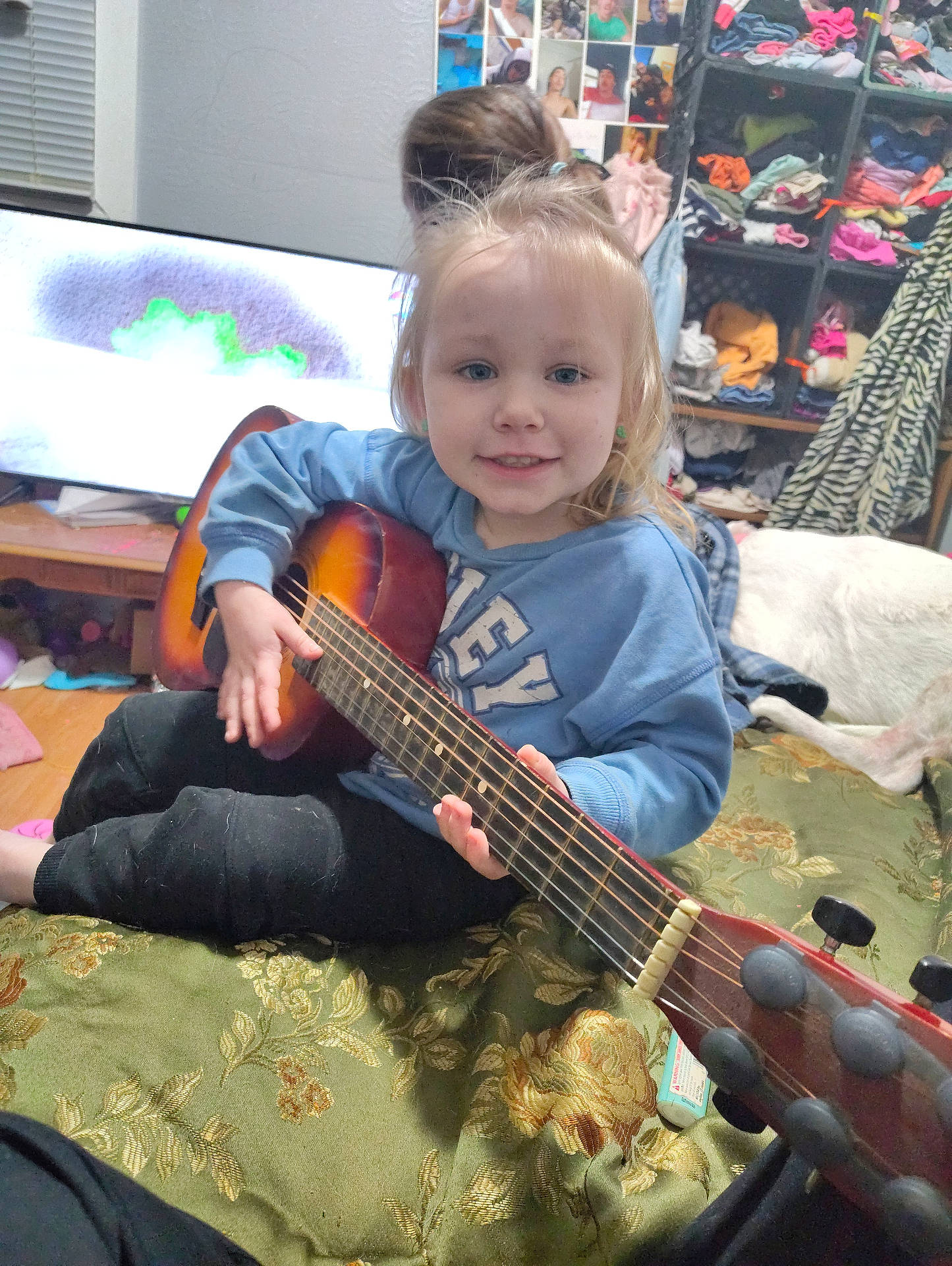 Willow is registered to the contest to win money with this photo: baby, child, computerhardware, electronics, face, female, furniture, girl, guitar, guitarist, hardware, head, leisureactivities, monitor, music, musicalinstrument, musician, performer, person, screen