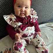 Loëlya participe au concours pour gagner de l'argent avec cette photo : baby, child, headband, red, floral_outfit, couch, smile, hand, nails, blue_eyes, cute, clothing, footwear, sitting, indoor, person, infant, portrait, fingers, fabric