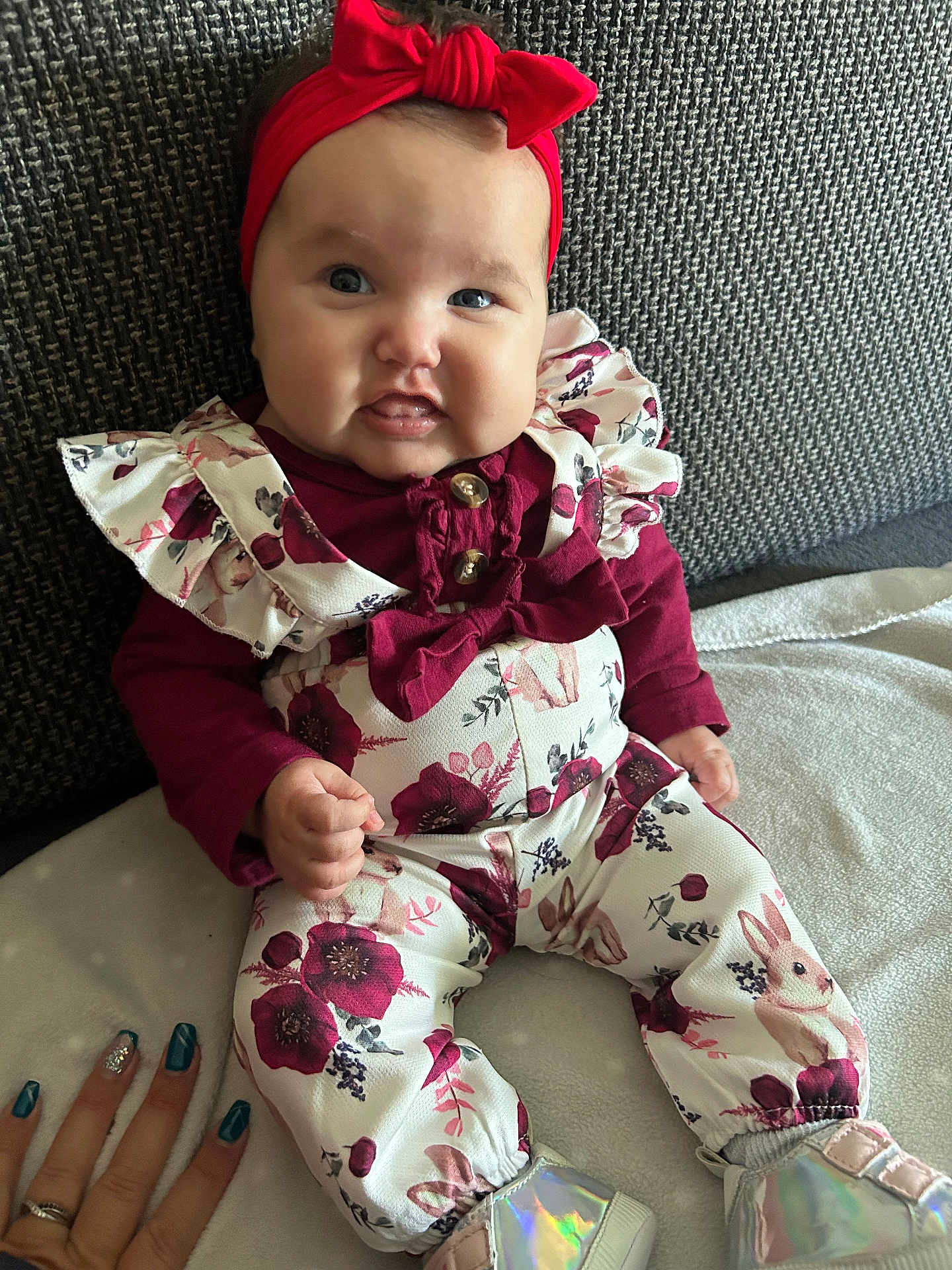Loëlya participe au concours pour gagner de l'argent avec cette photo : baby, child, headband, red, floral_outfit, couch, smile, hand, nails, blue_eyes, cute, clothing, footwear, sitting, indoor, person, infant, portrait, fingers, fabric