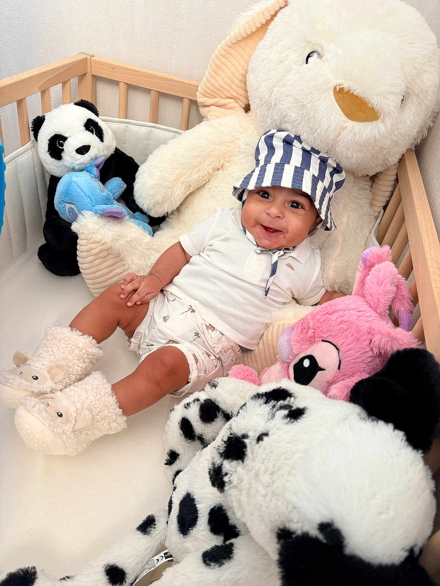 Kayden a rejoint le concours — aidez-le/la à gagner de superbes lots ! baby, child, crib, stuffed_animal, plush_toy, panda, pink_toy, blue_toy, hat, smile, happy, boots, white_clothing, indoor, soft_toy, cute, childrens_room, cozy, playroom, infant