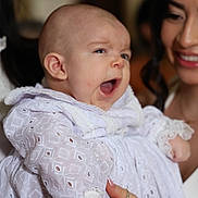 Matias is registered to the contest to win money with this photo: baby, infant, woman, smile, yawn, white_clothing, lace, portrait, indoor, person, holding, cute, happy, face, skin, head, family, love, people, closeup