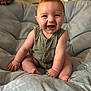Wesley is registered to the contest to win money with this photo: baby, bright_eyes, buttoned_clothing, child, chubby_cheeks, cushion, cute, foot, green_clothing, hand, happy, head, indoor, infant, plush_chair, portrait, romper, sitting, skin, smiling