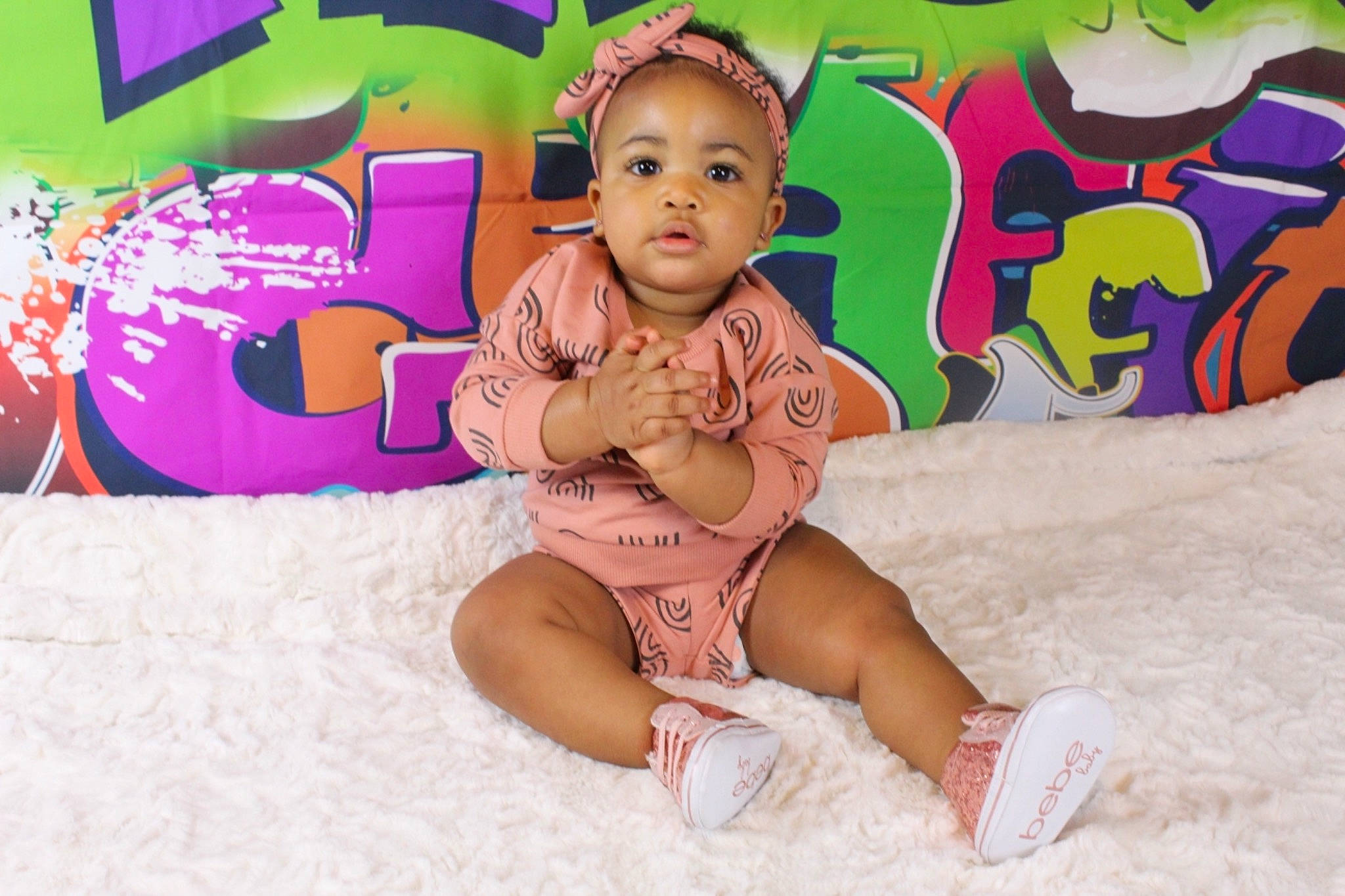 Imani is registered to the contest to win money with this photo: baby, baby_toddler_clothing, child, comfort, foot, fun, happy, human_leg, knee, leisure, magenta, pattern, person, pink, play, room, sitting, smile, thigh, thumb