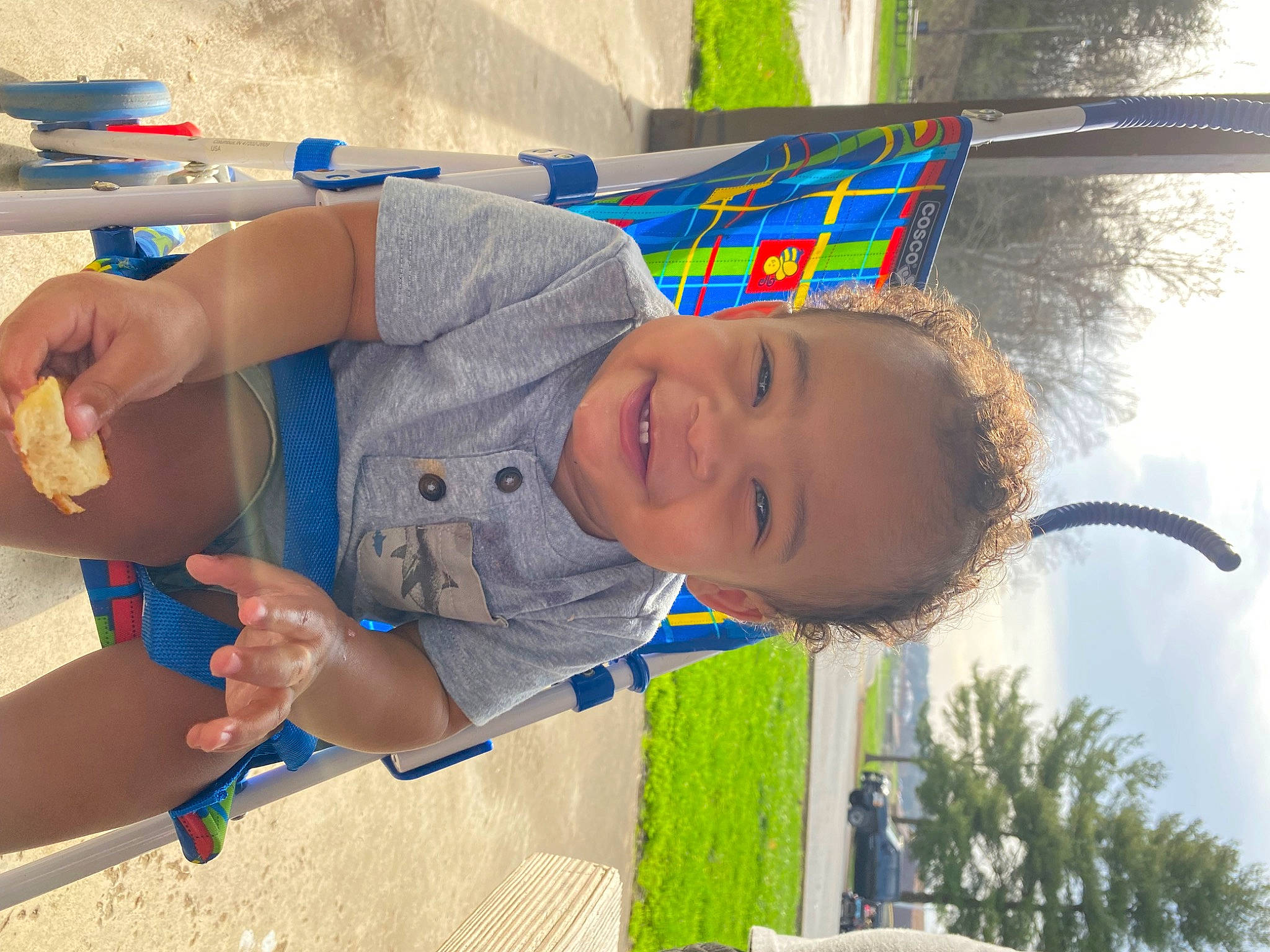 Jakobie is registered to the contest to win money with this photo: baby_toddler_clothing, blue, child, electric_blue, fun, grass, happy, leisure, person, photograph, play, recreation, shade, smile, summer, t_shirt, toddler, tree, vacation, window