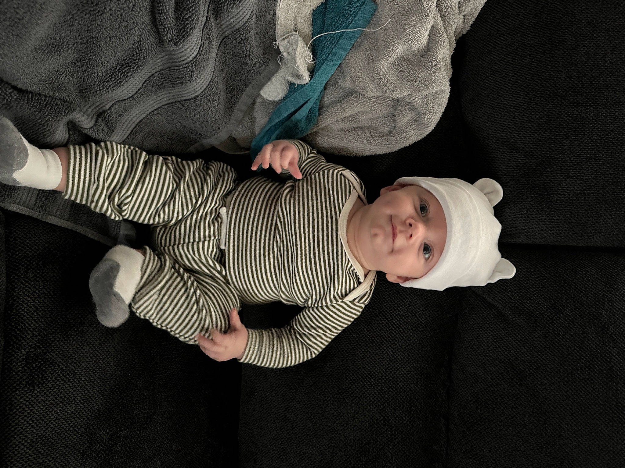 Carter is registered to the contest to win money with this photo: baby, baby_products, baby_toddler_clothing, cheek, child, comfort, finger, flooring, gesture, headwear, human_body, pattern, person, sitting, sleeve, thumb, toddler, tree, wood
