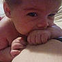 Matilda joined the competition — help win amazing prizes! baby, infant, hand, face, skin, bed, bedding, person, lying_down, close_up, chewing, fist, arm, child, indoors, soft_light, casual, candid, human, young