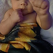 Matilda is registered to the contest to win money with this photo: baby, infant, blanket, close_up, cute, child, fist, hand, face, skin, portrait, wrapped, young, newborn, expression, looking, indoors, soft, warm, comfort