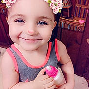 Kelly is registered to the contest to win money with this photo: toddler, child, smiling, flower_crown, filter, indoor, bottle, sunglasses, barefoot, tank_top, shorts, wooden_decor, statue, happy, cute, portrait, face, person, playful, young_child