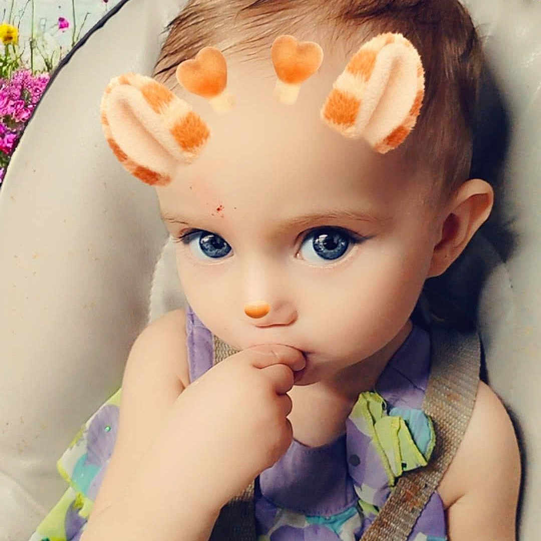 Lizzy joined the competition — help win amazing prizes! animal_ears, baby, blue_eyes, bottle, child, colorful_dress, curious_expression, cute, face, filter, flower_background, hand, heart_shapes, high_chair, indoor, portrait, seatbelt, sky, thumb_sucking, toddler