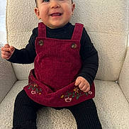 Romia a rejoint le concours — aidez-le/la à gagner de superbes lots ! toddler, child, smiling, red_dress, black_clothing, boots, sitting, chair, portrait, indoor, happy, face, cute, baby, embroidery, furniture, textured_fabric, person, young_child, casual