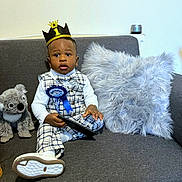 Jad Kylian joined the competition — help win amazing prizes! toddler, birthday, crown, plaid_outfit, bowtie, ribbon, tablet, sofa, pillow, stuffed_animal, koala, white_shirt, socks, footwear, indoor, celebration, child, portrait, cute, happy