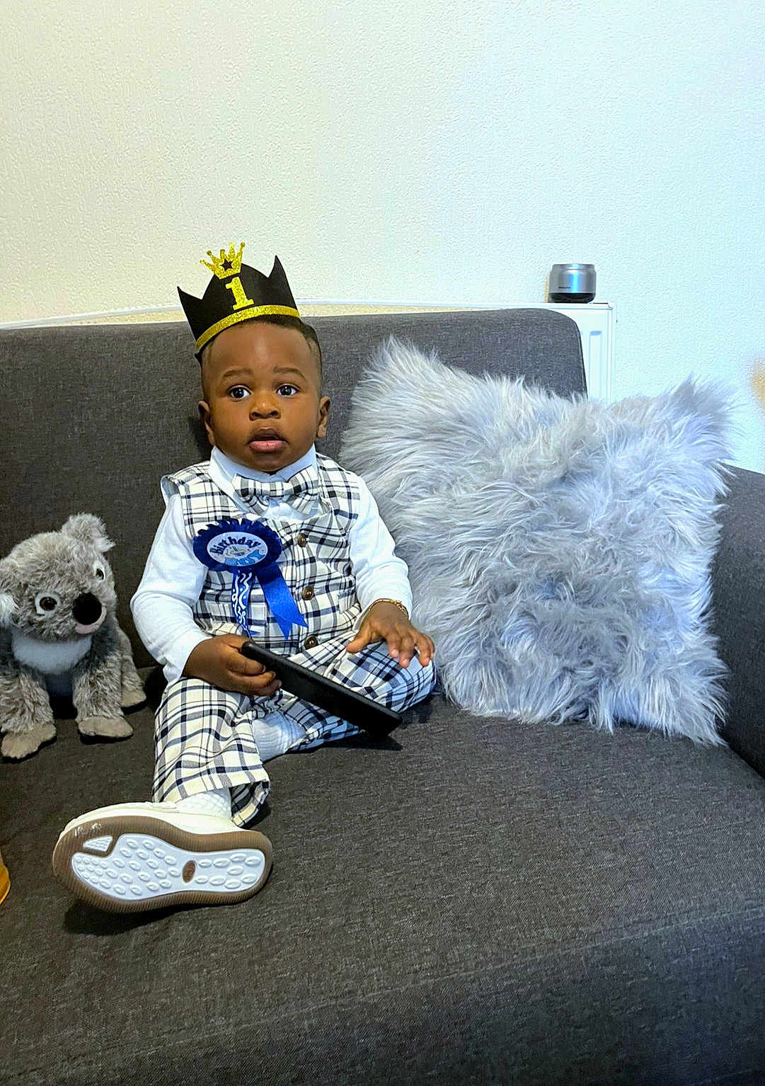 Jad Kylian joined the competition — help win amazing prizes! toddler, birthday, crown, plaid_outfit, bowtie, ribbon, tablet, sofa, pillow, stuffed_animal, koala, white_shirt, socks, footwear, indoor, celebration, child, portrait, cute, happy