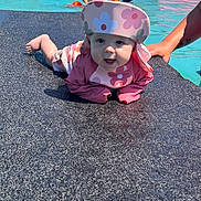 Skylynn is registered to the contest to win money with this photo: baby, child, pool, swimming_pool, water, sun_hat, floral_clothing, pink_clothing, infant, smiling, happy, outdoor, summer, vacation, pool_deck, inflatable, ball, adult, family, portrait