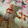 Skylynn is registered to the contest to win money with this photo: baby, child, infant, portrait, lying_down, smiling, headband, flower_headband, dress, stars, blanket, floral, pink, orange_flowers, calendar, numbers, indoor, bed, playful, photography