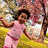 Safia joined the competition — help win amazing prizes! toddler, child, pink_clothing, knitted_outfit, smiling, outdoor, spring, blossom, tree, grass, nature, happy, playing, daylight, park, curly_hair, person, cute, young_child, sunny
