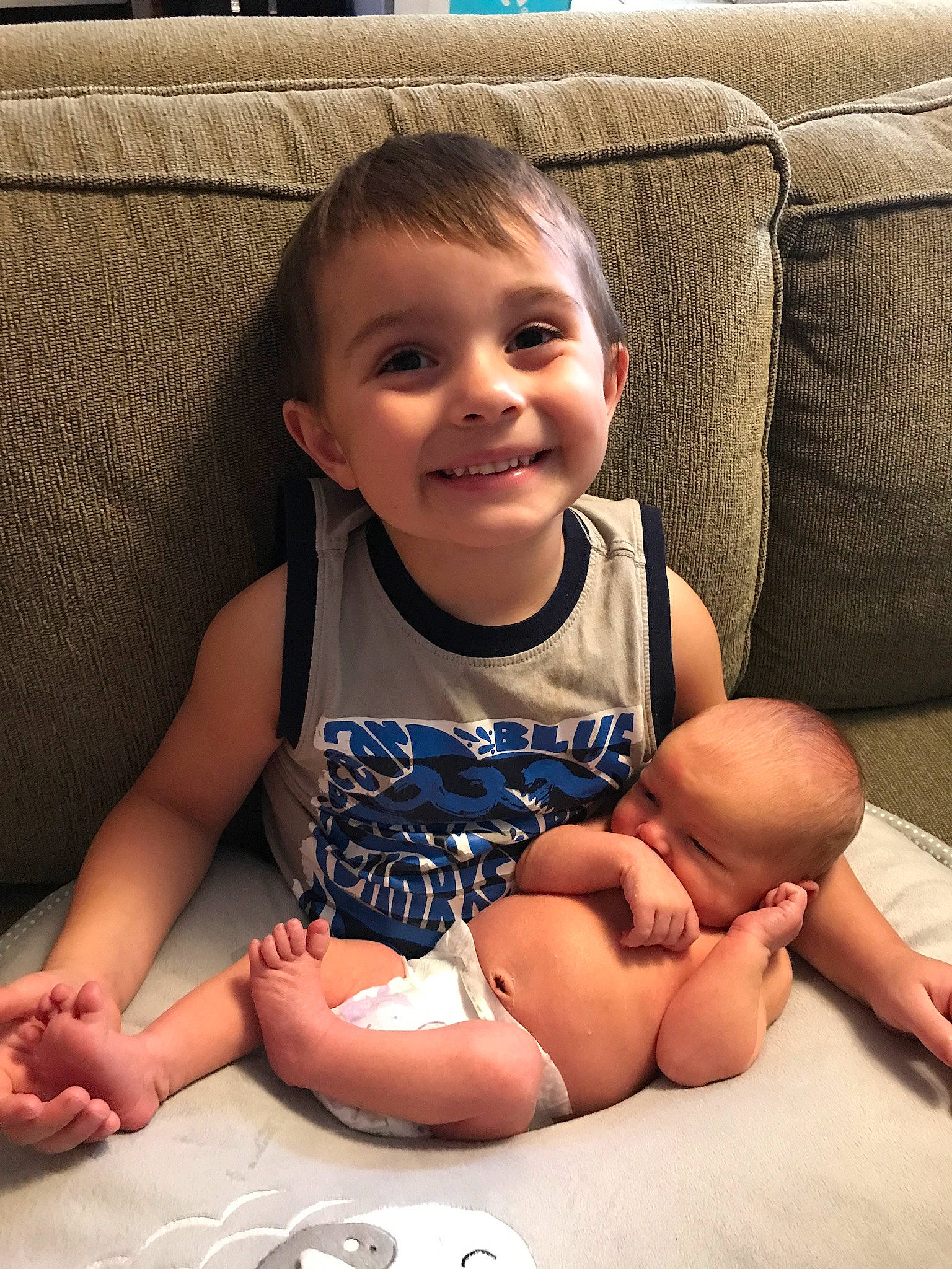 River is registered to the contest to win money with this photo: arm, baby, cheek, child, face, finger, hand, happy, head, joy, leg, person, sibling, sitting, skin, smile, thumb, toddler