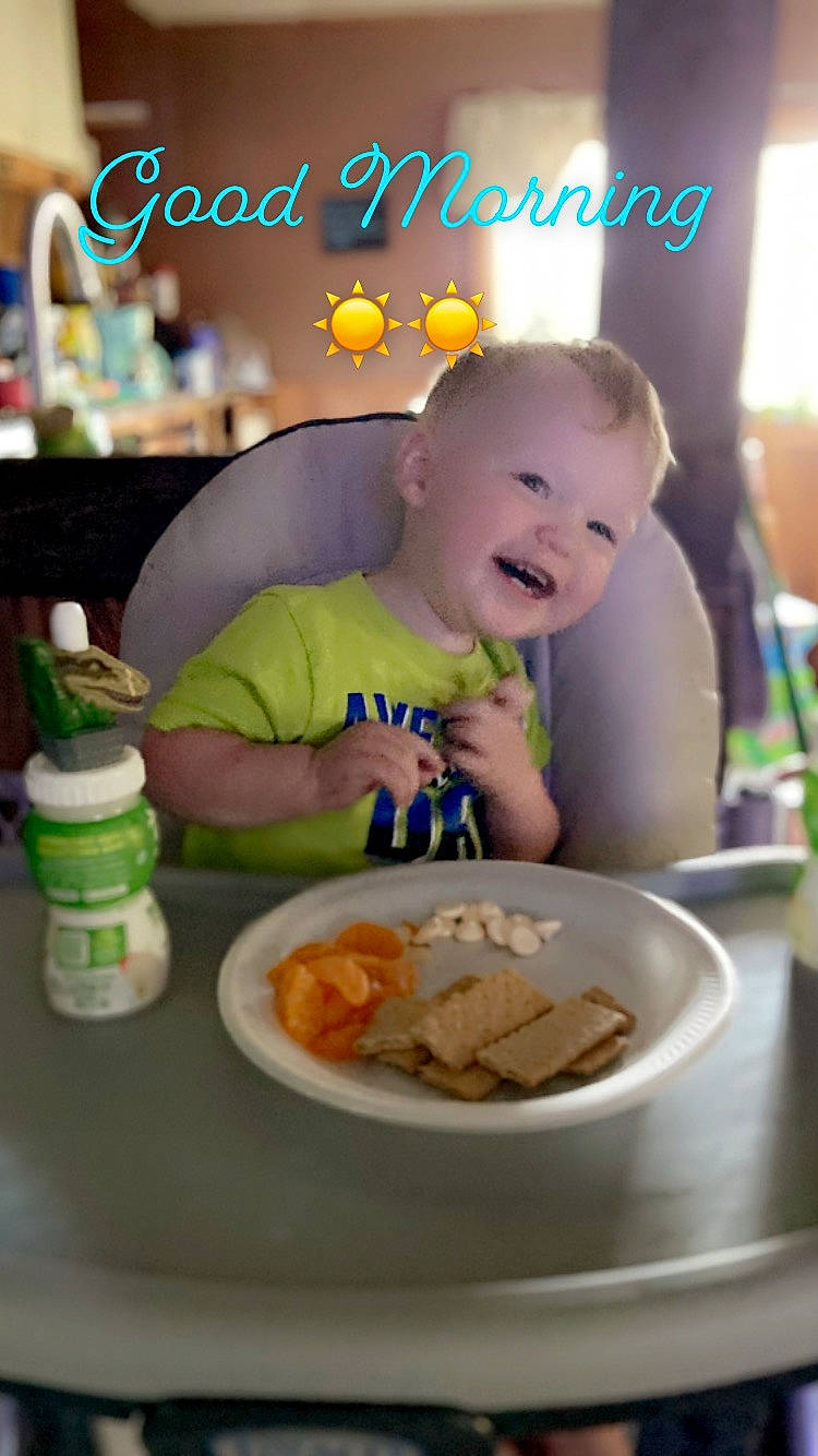 Archer is registered to the contest to win money with this photo: baby, baby_toddler_clothing, chair, child, cuisine, dish, dishware, drinkware, food, food_craving, happy, junk_food, person, plate, platter, serveware, sharing, smile, table, tableware
