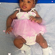 Tyniyah is registered to the contest to win money with this photo: baby, infant, girl, pink_tutu, headband, socks, lying_down, curious_expression, blue_background, hearts_overlay, cute, child, portrait, soft_lighting, adorable, clothing, floor, skin, closeup, happy