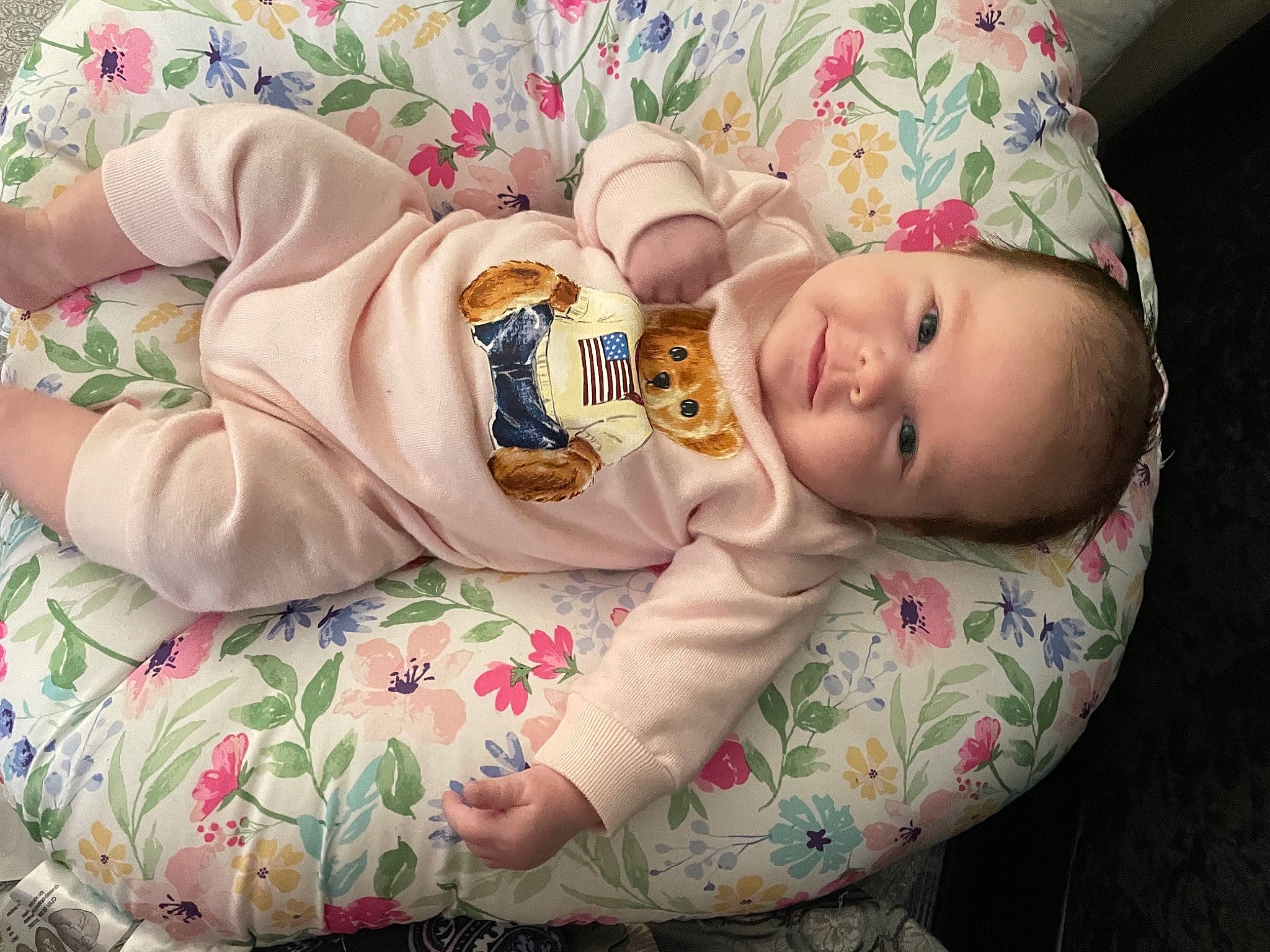 Adalena is registered to the contest to win money with this photo: arm, baby, baby_products, baby_sleeping, baby_toddler_clothing, cheek, child, comfort, eye, face, happy, head, linens, pattern, person, pink, sitting, skin, sleeve, smile