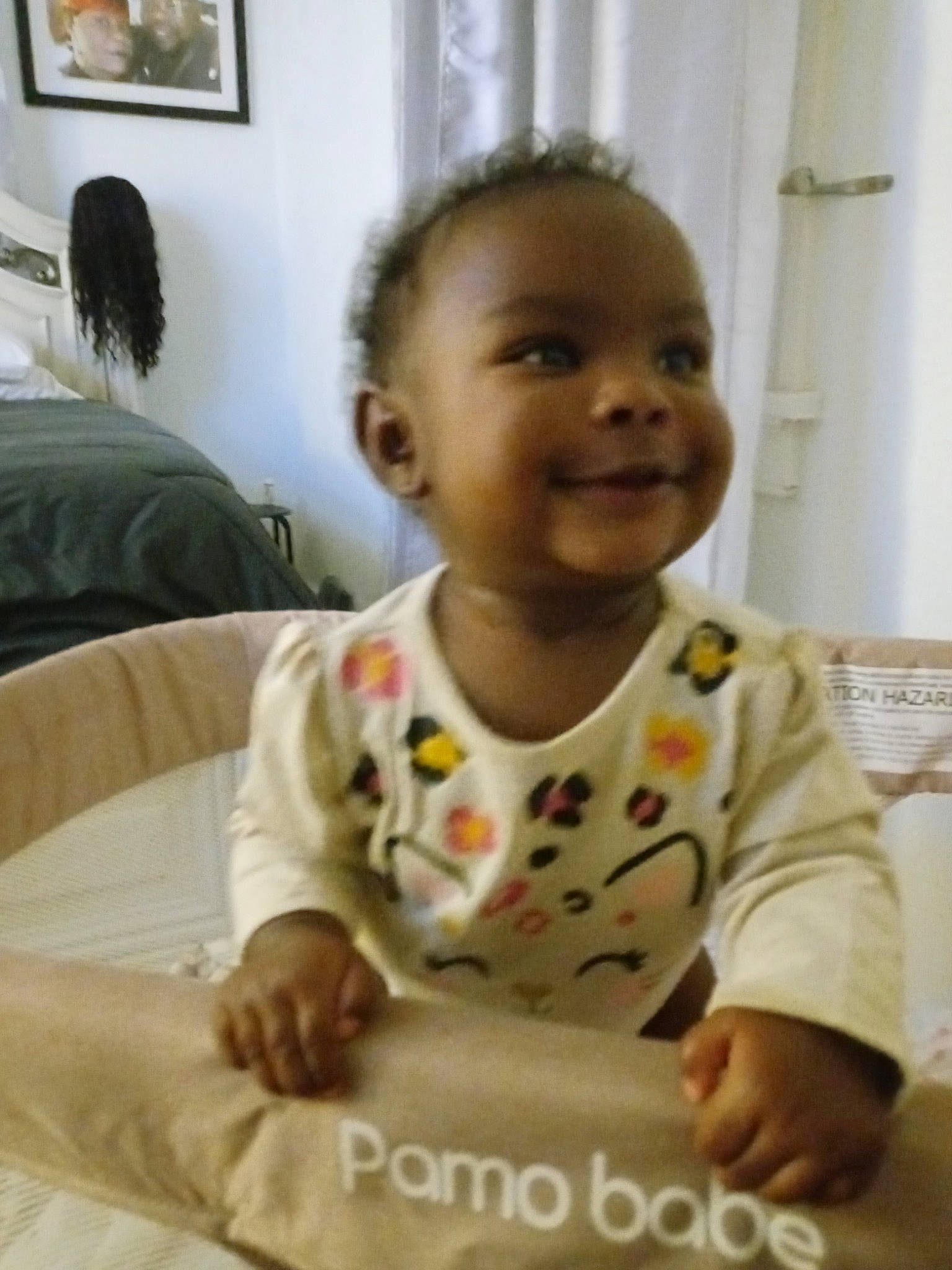 Dakota is registered to the contest to win money with this photo: baby, baby_toddler_clothing, cheek, child, chin, comfort, curtain, dress, floor, flooring, fun, happy, joy, nose, person, picture_frame, room, sitting, skin, sleeve