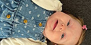 Hortense a rejoint le concours — aidez-le/la à gagner de superbes lots ! baby, child, smiling, face, blue_eyes, hair_clip, denim, dress, heart_pattern, white_sweater, button, portrait, lying_down, indoor, cute, happy, skin, person, infant, cozy
