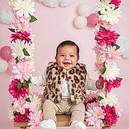 Ada Gaitán joined the competition — help win amazing prizes! baby, swing, flowers, pink_background, smiling, leopard_print, vest, balloons, clouds, cute, child, happy, indoor, portrait, toy, decor, soft_lighting, infant, playful, seated