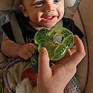 Xavier joined the competition — help win amazing prizes! baby, infant, smile, happy, teething_toy, hand, tattoo, plush_toy, bunny, cushion, seat, child, cute, indoors, portrait, closeup, person, playful, toy, comfort