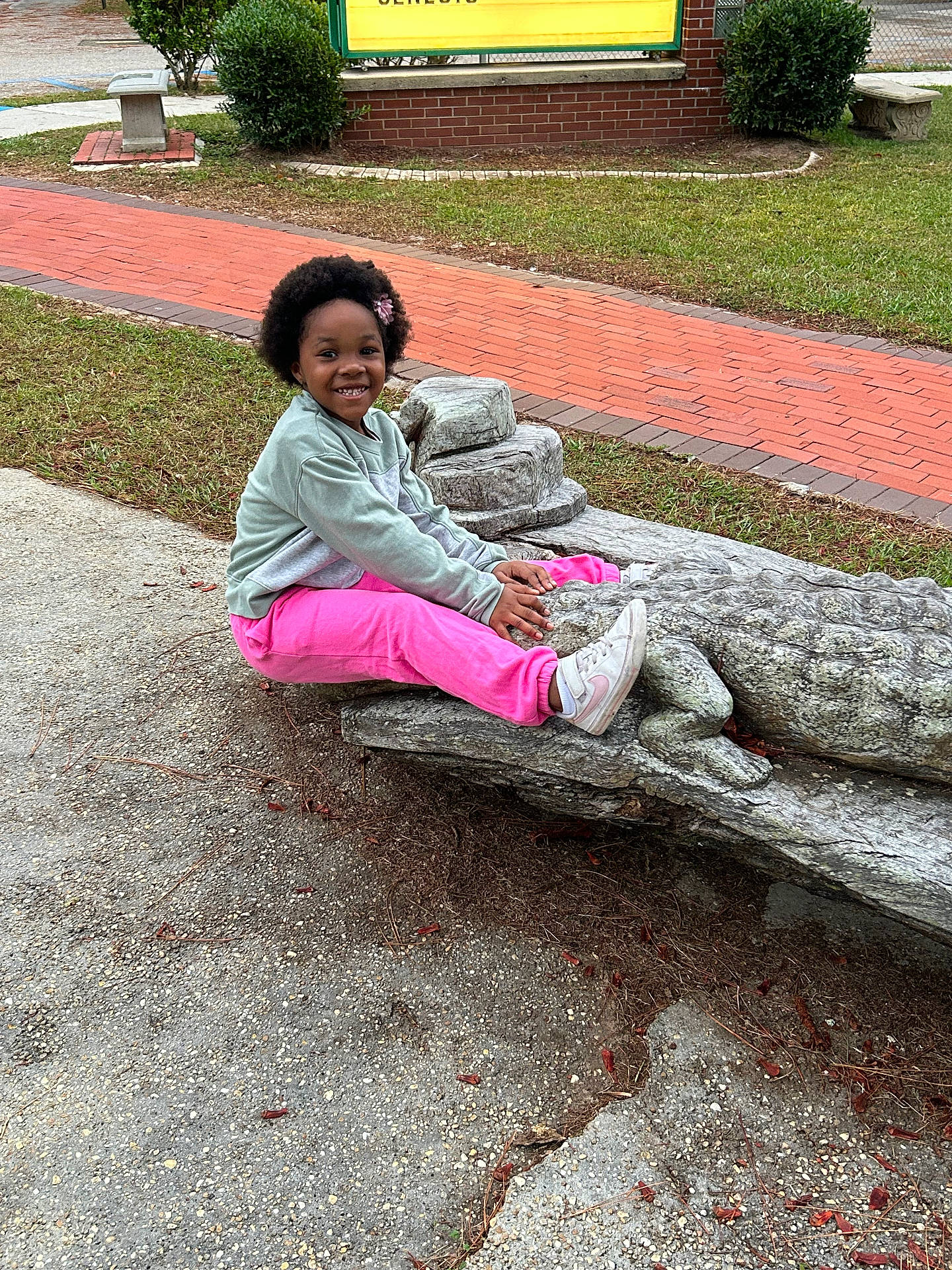 Nevaeh is registered to the contest to win money with this photo: bench, child, clothing, face, female, furniture, grass, head, nature, outdoors, pants, park, path, person, photography, plant, portrait, sitting, slate, walkway